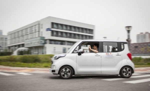 자율주행 기술을 탑재한 기아차 '레이'에서 운전자가 양손을 운전대에서 뗀 채 연세대 송도캠퍼스 도로를 달리고 있다. (사진제공=SK텔레콤)