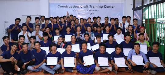 포스코건설이 미얀마에서 운영한 건설기능직업훈련소 수료생들이 기념촬영하고 있다. (사진제공=포스코건설)