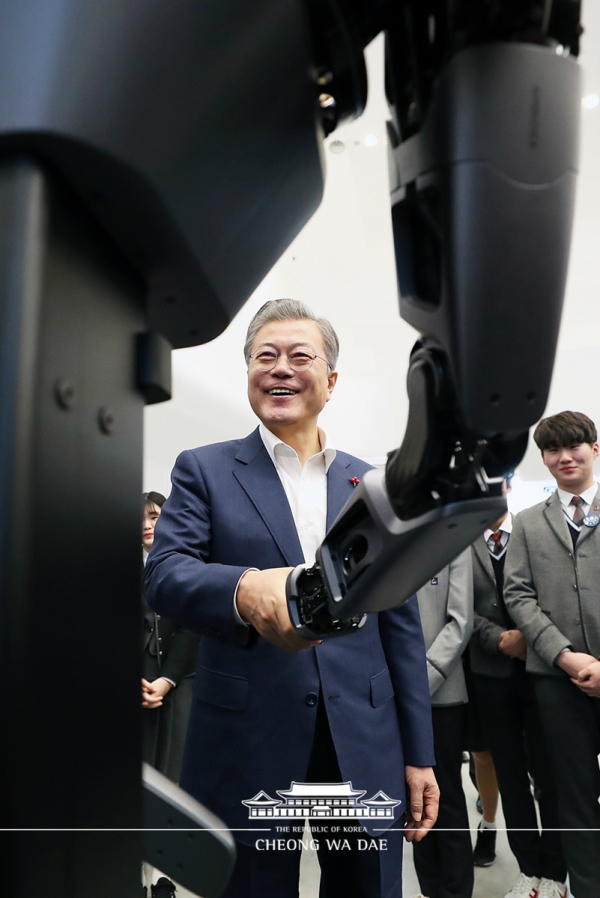 문재인 대통령이 29일 DDP에서 열린 ‘한국 전자·IT산업 융합 전시회’에서 네이버랩스 지능형 로봇팔인 ‘앰비덱스’와 악수하고 있다.