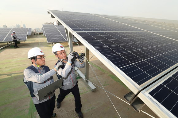 KT의 에너지 전문인력들이 KT 구로타워 옥상에 구축된 태양광 발전소에서 태양광 발전시설을 점검하고 있다. <사진제공=KT>