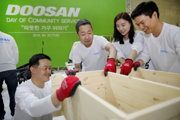 박정원(오른쪽 세 번째) 두산그룹 회장이 임직원들과 함께 지역 가정에 보낼 가구를 만들고 있다. (사진제공=두산그룹)