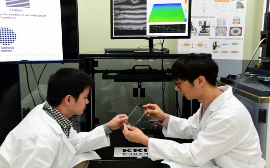 KRISS 김영식 책임연구원(오른쪽)팀이 스마트폰 커버 글라스를 검사하고 있다.