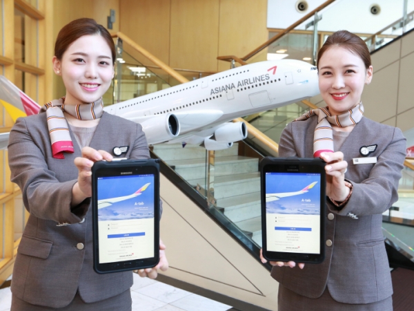 아시아나항공 캐빈승무원들은 스마트 워크 플랫폼을 적용한 A-tab 시스템 화면을 보이고 있다.(사진=아시아나항공)