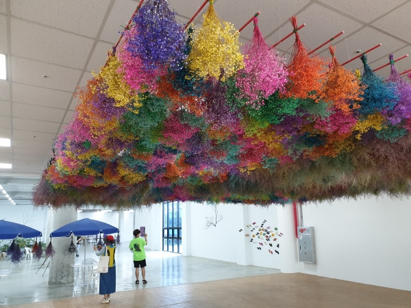 '허브에센스 만들기 체험프로그램장'으로 가는 길에는 천장에 매달려 있는 형형색색의 꽃이 여행객을 반긴다. (사진= 원성훈 기자)