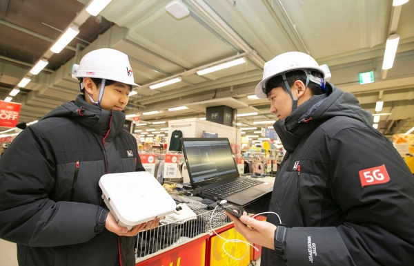 KT 네트워크부문 직원들이 경기도 안양시 홈플러스 매장 내에 '고성능 광중계기'를 설치하고, 5G 서비스 품질을 확인하고 있다. (사진제공=KT)