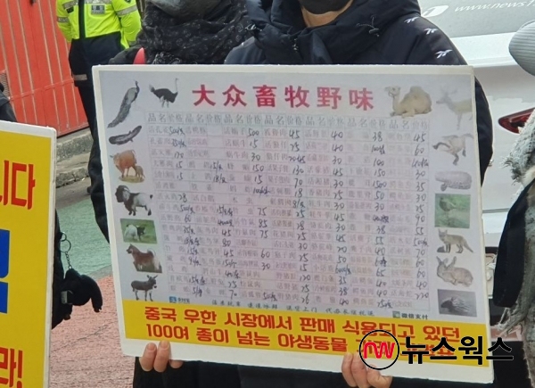 29일 야생동물 식용 중단을 촉구하는 기자회견에 참석한 한국동물보호연합 회원이 '중국 우한 시장에서 판매, 식용되고 있던 100여 종이 넘는 야생동물 거래 가격표'라 적힌 손팻말을 들고 있다. (사진=전다윗 기자)