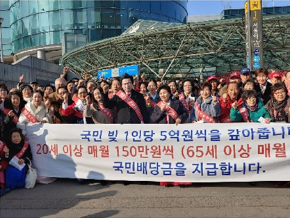 지난 24일 서울역 앞에서 지지자들에 둘려 쌓여 자신의 공약을 소개하고 있는 허경영 배당금당 대표(앞줄 왼쪽 여섯 번째). (사진제공= 배당금당)