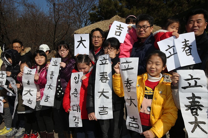 서울 길동생태공원에서 아이들이 가족과 함께 쓴 입춘대길 입춘방을 들고 사진을 찍고 있다. <사진=서울시>