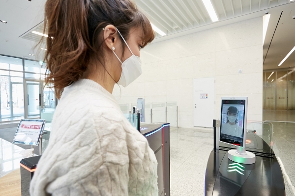 LG CNS 본사 출입게이트에서 직원이 얼굴인식 출입통제 단말기에 얼굴을 인식하고 있다. 마스크를 쓰더라도 AI를 통해 인식이 가능하다. (사진제공=LG CNS)