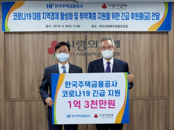 이정환(왼쪽) 한국주택금융공사 사장이 신정택 부산 사회복지공동모금회장에게 지원금품 전달하고 있다. (사진제공=주택금융공사)
