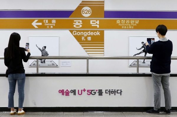 서울 지하철 6호선 공덕역에 마련된 'U+5G 갤러리'에 방문한 고객이 'U+AR' 앱으로 작품을 체험·감상하고 있다. (사진제공=LG유플러스)
