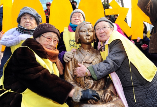 1000차 수요시위 당시, 위안부 피해 할머니들이 '평화의 소녀상'을 끌어안고 있다. (사진=정의기억연대 홈페이지)