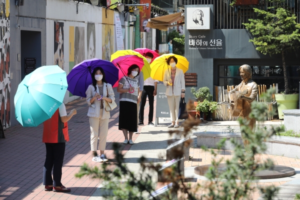 대구 중구 근대골목 투어 여행객들이 양산을 쓴 채 문화 해설사의 설명을 듣고 있다. (사진제공=대구 중구청)