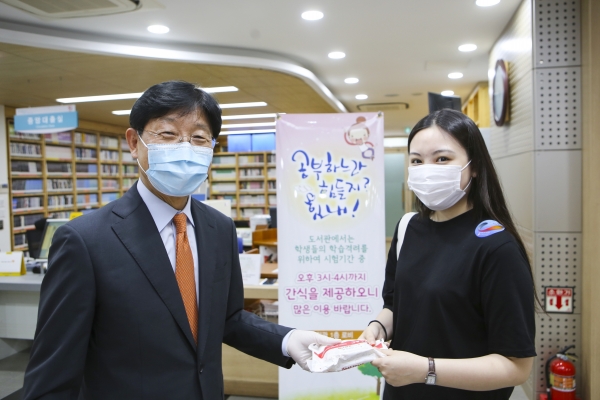 박승호 계명문화대 총장(왼쪽)이 학생들에게 직접 간식을 나눠주고 있다. (사진제공=계명문화대)