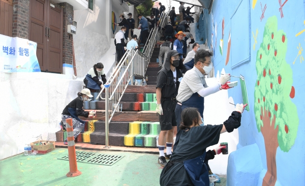 봉사단원들이 배다리 마을에서 벽화 봉사활동을 하고 있다. (사진제공=포스코건설)