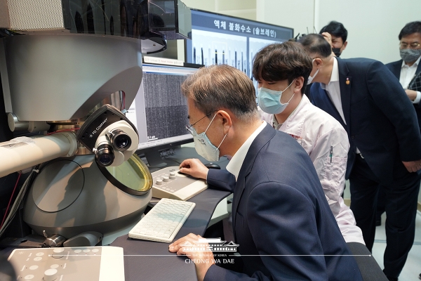 문재인 대통령이 9일 SK하이닉스를 찾아 액체불화수소 시제품을 분석하는 곳에서 직접 전자현미경으로 테스트를 해보고 있다. (사진제공=청와대)