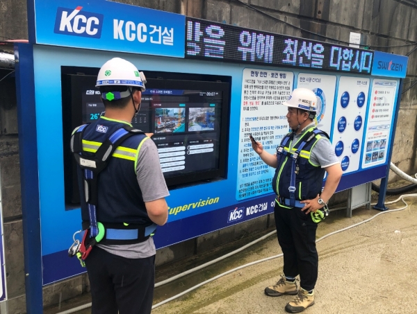 KCC건설 공사현장에서 직원들이 DID(digital information display)를 통해 위험요인, 유해요인 등 현장내 각종 정보를 확인하고 있다. (사진제공=KCC건설)