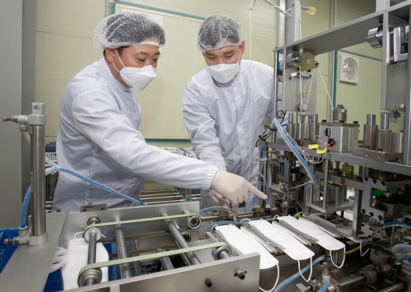 대전에 위치한 마스크 제조기업 '레스텍'에서 박나원(오른쪽) 공장장과 권오창 삼성전자 스마트공장지원센터 멘토가 마스크 본체와 귀끈 연결 상태를 점검하고 있다. (사진제공=삼성전자)