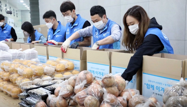 신한생명 직원들이 지난 23일 서울시 구로구에 비영리 NGO '함께하는 사랑밭' 사무소에서 농산품 키트를 제작하고 있는 모습. (사진제공=신한생명)