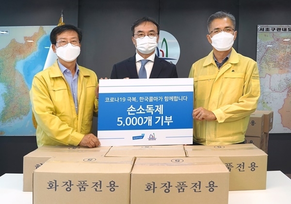 이정규(가운데) 한국콜마 상무가 지난 22일 서울 서초구청을 방문해 손소독제를 기부하고 있다. (사진제공=한국콜마)