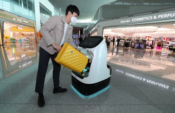 인천국제공항공사 관계자가 인천공항 제2여객터미널 출국장에서 자율주행 카트로봇을 이용하고 있다. (사진제공=인천공항공사)