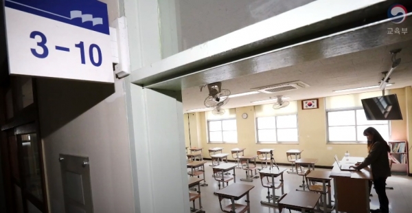 등교 중지로 인해 비어 있는 교실에서 한 교사가 원격수업을 준비하고 있다. (사진=유튜브 교육부TV 캡처)