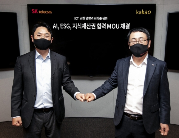 여민수(왼쪽) 카카오 공동대표와 유영상 SK텔레콤 MNO사업대표가 AI·ESG·지식재산권 분야 협력에 대한 업무협약을 체결한 뒤 손을 맞잡고 있다. (사진제공=SK텔레콤, 카카오)