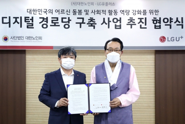 최택진(왼쪽) LG유플러스 기업부문장과 대한노인회 김호일 회장이 업무협약을 체결한 후 기념촬영을 하고 있다.