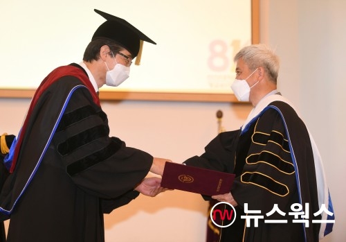 곽상욱(오른쪽) 오산시장이 연규홍 한신대학교 총장으로부터 명예박사 학위를 받고 있다(사진제공=오산시)