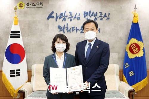 장 의장(오른쪽)이 김정희 총무팀장에게 임명장을 교부하고 있다(사진제공=경기도의회)