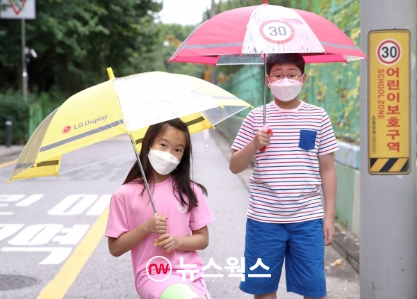 어린이들이 LG디스플레이가 준비한 '투명 안전 우산'을 쓰고 있다. (사진제공=LG디스플레이)