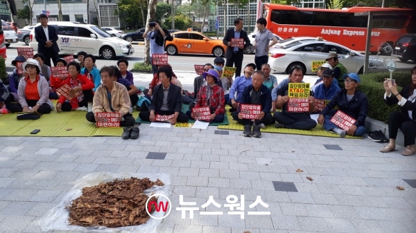 전북 익산 장점마을(일명, '암 마을') 피해주민들이 지난 2019년 말에 서울 KT&G 본사 앞에서 연초박을 인도 위에 깔아놓고 집회를 열고 있다. (사진=원성훈 기자)