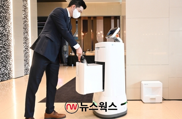 호텔 직원이 LG 클로이 서브봇의 서랍에 고객이 주문한 와인을 담고 있다. (사진제공=LG전자)