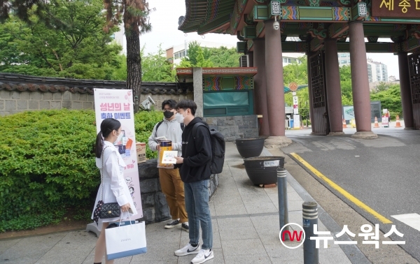 뉴스웍스 관계자들이 서울시 광진구 소재 세종대학교 앞에서 젊깨 책자를 나눠주며 2021년 '성년의 날 축하 온라인 이벤트'를 설명하고 있다. (사진=이한익 기자)