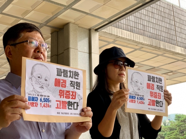 가습기살균제 피해자들이 13일 오전 서울중앙지검 로비에서 손팻말을 들고 기자회견을 하고 있다. (사진제공=가습기살균제 참사 전국네트워크)