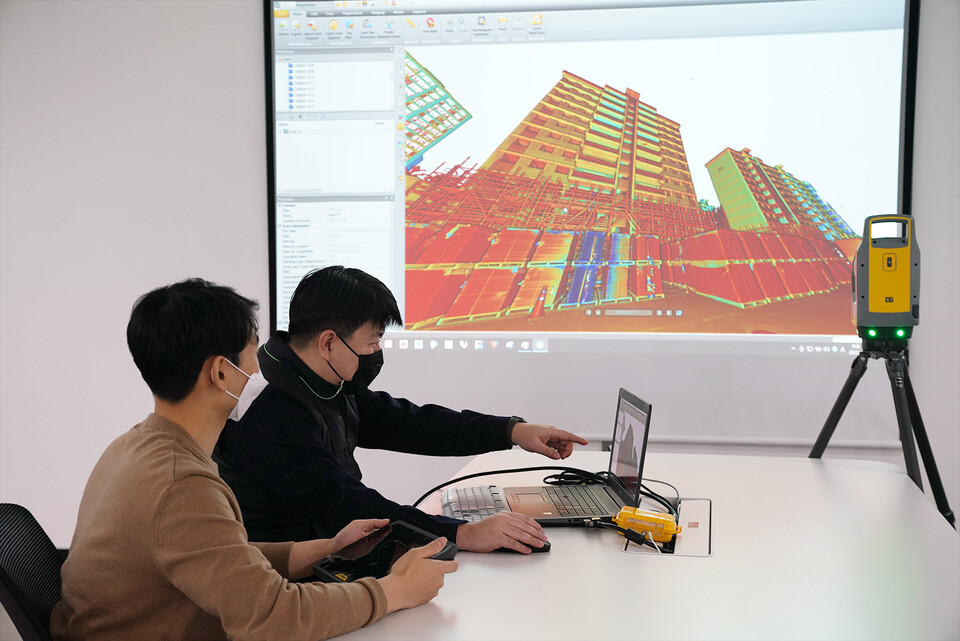롯데건설 관계자가 3D 스캐너를 활용한 기존 아파트 모델링 데이터를 확인하고 있다. (사진제공=롯데건설)