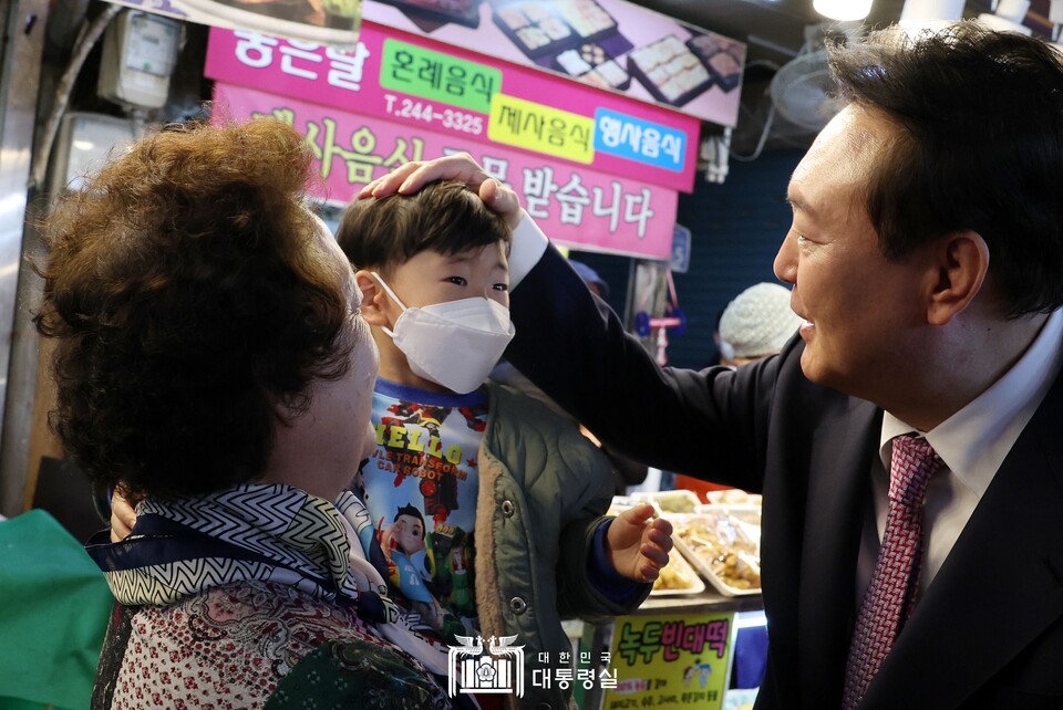 9일 울산 신정시장을 방문한 윤석열(오른쪽) 대통령이 어린아이의 머리를 쓰다듬고 있댜. (사진제공=대통령실)