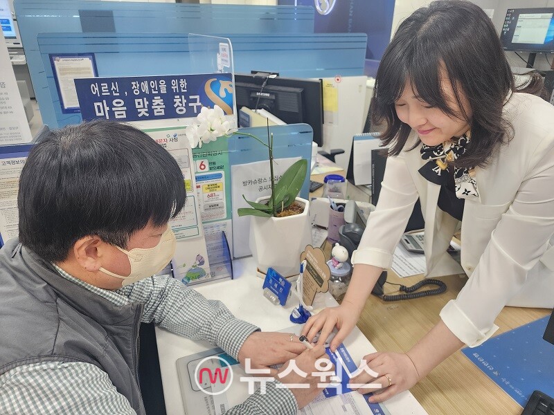 20일 서울 소재 신한은행 영업점에서 직원이 '마음맞춤 응대 KIT'를 활용해 시각장애인과의 업무를 진행하고 있다. (사진제공=신한은행)
