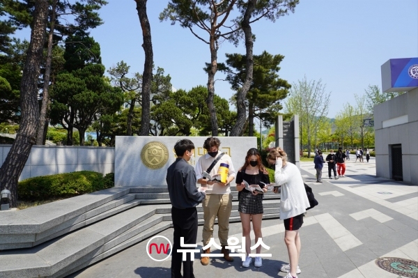 지난해 5월 16일 서울 서대문구 연세대학교 정문 앞에서 외국인 학생들이 '젊깨' 책자를 받아 보고 있다. (사진=이한익 기자)