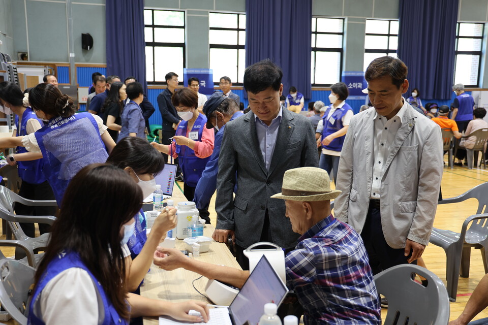 지난 17일 충남 홍성군 갈산중고등학교에서 여운철 NH농협생명 부사장(왼쪽)과 정명훈 갈산농협 전무(오른쪽)가 검진받는 조합원을 살피고 있다. (사진제공=NH농협생명)