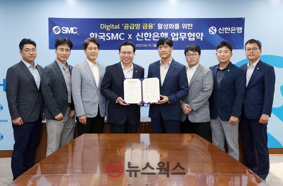 전필환(왼쪽 네 번째) 신한은행 디지털혁신부문장과 홍성진(왼쪽 다섯 번째) 한국SMC 관리본부장이 19일 서울 중구 신한은행 본점에서 진행된 디지털 공급망 금융 활성화를 위한 업무협약식에서 양사 직원들과 함께 기념촬영하고 있다. (사진제공=신한은행)