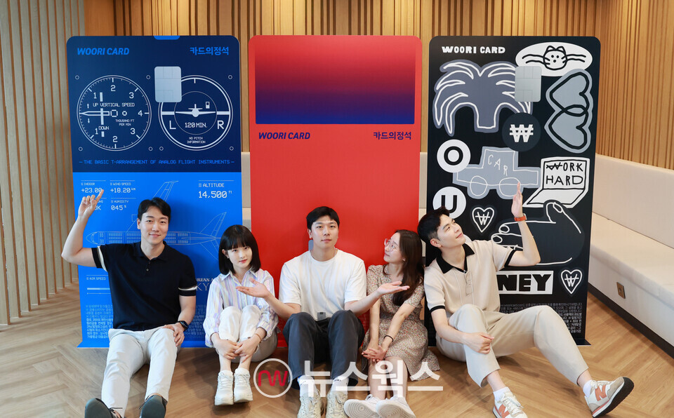 이달 24일 첫 독자카드 3종 '카드의정석' 출시를 기념해 사내 크리에이터 5인이 우리카드 광화문 본사 이벤트 포토존에서 포즈를 취하고 있다. 왼쪽 카드부터 카드의정석 에브리 마일 스카이패스·에브리원·에브리체크. (사진제공=우리카드)