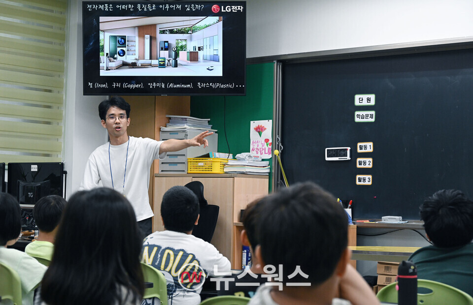 지난 11일 서울 중구에 위치한 충무초등학교에서 'E-순환학교' 일일교사로 나선 LG전자 직원이 폐전자제품 재활용 방법을 초등학생들에게 알기 쉽게 설명하고 있다. (사진제공=LG전자)