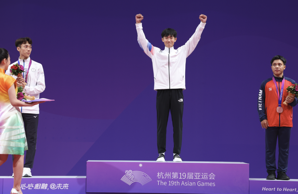 24일 중국 항저우 린안 스포츠문화·전시센터에서 열린 2022 항저우 아시안게임 태권도 품새 남자 개인전 1위를 차지한 강완진이 단상에 올라 두 손을 들어 기뻐하고 있다. (사진=뉴스1)