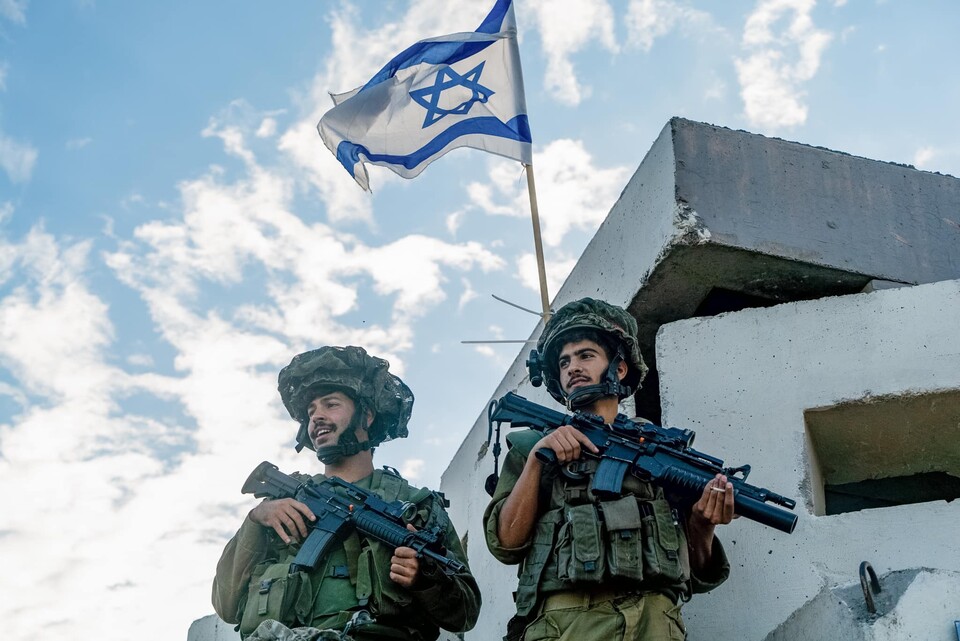 이스라엘 국기 앞에 서 있는 이스라엘 군인들. (출처=IDF 페이스북)
