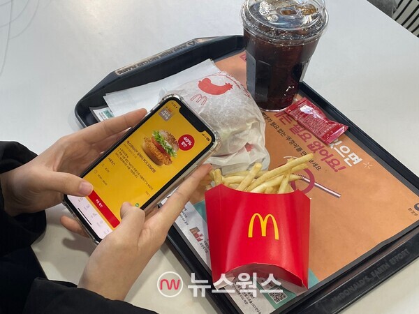 한 소비자가 맥도날드 자사앱 M오더로 40% 할인된 가격으로 햄버거를 주문하고 있다. (사진=김다혜 기자)