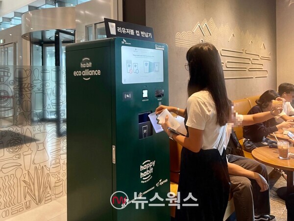서울시 종로구에 위치한 스타벅스 매장에서 한 소비자가 리유저블 컵 반납기에서 컵을 반납하고 있다. (사진=김다혜 기자)
