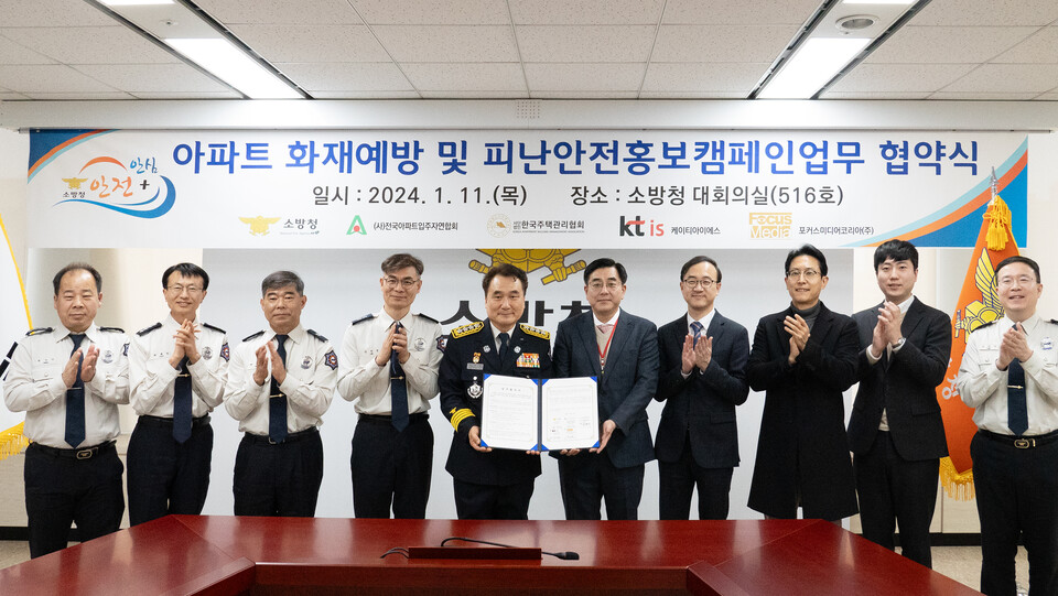 남화영 소방청장(왼쪽에서 다섯 번째)과 KTis 김한성 디지털광고사업본부장이 양 기관 임직원들이 참석한 가운데 MOU를 체결 후 협약서를 들어보이고 있다. 