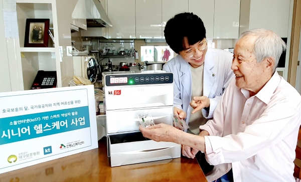 대구 보훈병원 방문간호사(왼쪽)가 스마트 약상자를 이용해 국가유공자 김갑생씨에게 복약 지도를 하고 있다. (사진제공=KT)