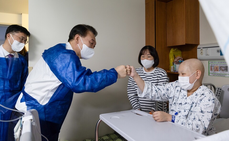 윤석열 대통령이 18일 서울아산병원 어린이병원을 찾아 한 환아를 격려하며 주먹 인사를 하고 있다. (사진제공=대통령실)